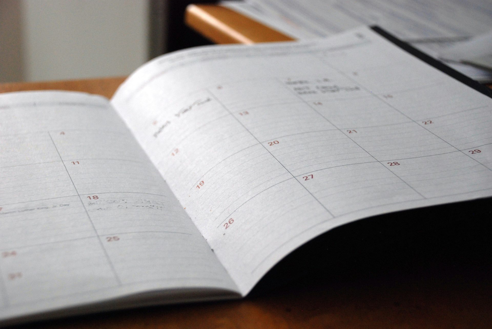 open monthly planner on wooden desk